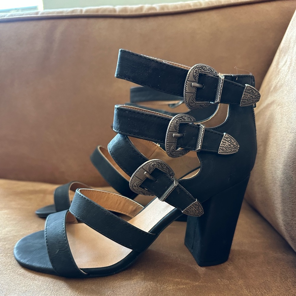 Black heels with silver buckles on the side and zipper in the back. Size 8.5
